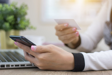 Hands holding credit card and using laptop. Online shopping