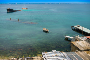 Sunken ship near old abandoned docks on the shore