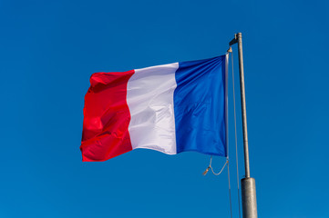 Naklejka na ściany i meble French flag waving against blue sky in Boulogne sur Mer, France.
