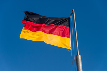 German flag waving against blue sky in Boulogne sur Mer, France.