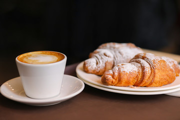 Cappuccino with hot croissant in cafe