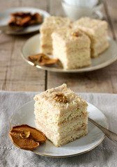 Pieces of apple cake and dried apples on a wooden table. Rustic style.