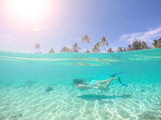HALF UNDERWATER: Young traveler enjoying a diving trip around exotic island.