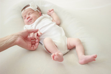 Mother holds her newborn baby for the hand
