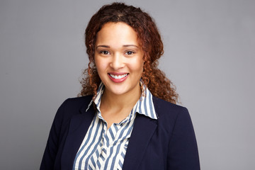 business woman smiling against gray background