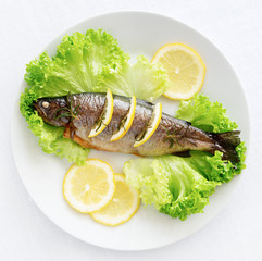 roasted trout, lettuce leafs, lemon slices, and rosemary