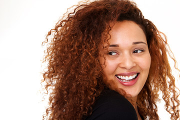 Close up beautiful young woman with curly hair laughing against isolated white background