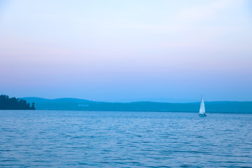 Obraz premium landscape on a big lake with a yacht and blue sky