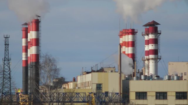 Air Pollution From Industrial Plants. Smoking industrial pipes. Red with white pipe.