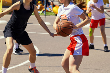 Naklejka premium Girls teenagers play basketball.