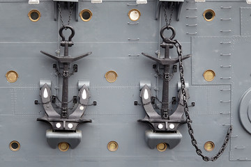 Two black anchors with a chain.