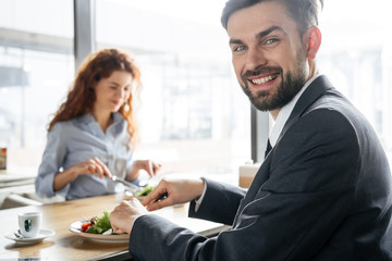 Businesspeople having business lunch at restaurant sitting eating salad man close-up smiling