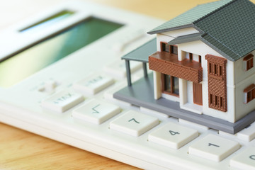 A model house model is placed on a calculator. as background property real estate concept with copy space for your text or  design.