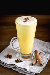 Pumpkin Latte with Spices Anise Cinnamon Sticks Tasty Latte with Whipped Cream Wooden background Vertical