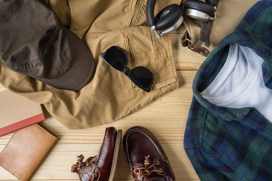 Casual Outfit And Accessories, Top View Of Flannel Plaid Shirt , Chino Pants And Casvas Sneakers On Wooden Backgroud