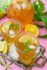 Sweet iced tea with mint, lemon and ice cubes