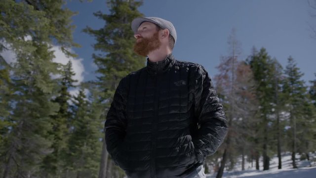 Mountain man, millenial, hipster pondering in the cold forest
