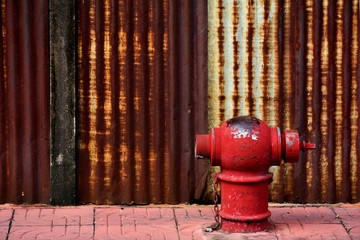 the old and damaged red fire head on pavement