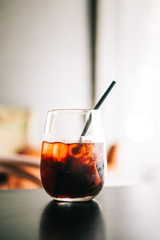 Black cold brew coffee with ice cubes in a glass. Hipster coffee shop. Minimalism drink photography
