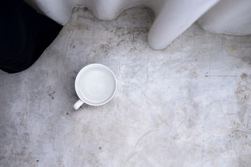 White cup with water on a light gray concrete background. Minimalism concept. Layout, copyspace for text