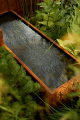 Rainwater tank in the garden for watering. Rusty rustic style.