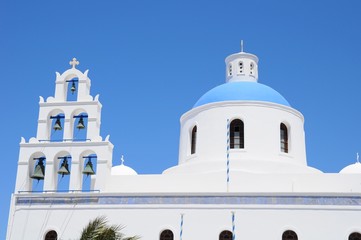 Obraz premium Famous stunning view of white architectures and church above the volcanic caldera in the village of Oia in Santorini island, Greece