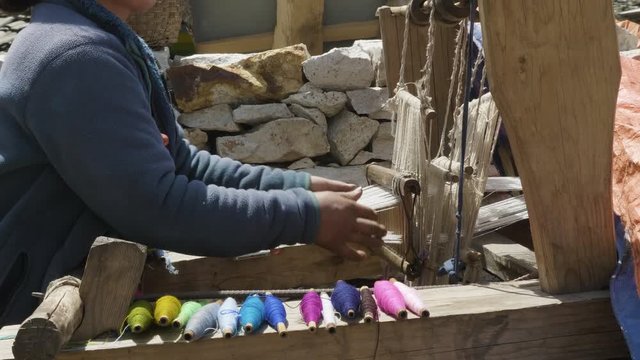 Nepalese woman weaves woolen scarf.