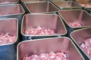 Pork in steel containers at a sausage factory. Line of production of sausage delicacies.