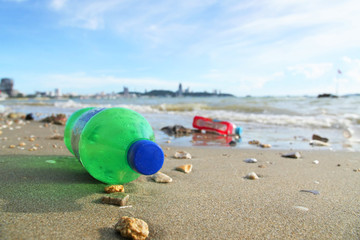 Waste plastic bottles are left on the beach.