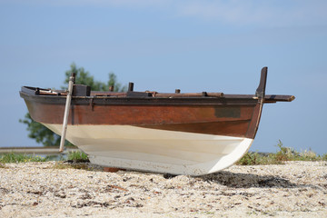 Obraz premium wooden fishing boat dries ashore