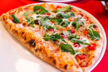 Neapolitan Pizza made with tomatoes, basil and mozzarella cheese.