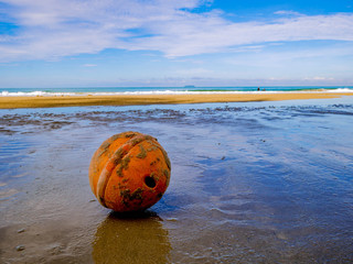 Old and Dirty Buoy Ball on the Beach in vacation time,Holiday with idyllic ocean,Summer concept