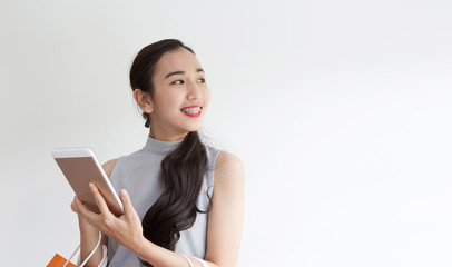 Naklejka premium Female buying online with tablet. Happy lady paying in coffee shop by smartphone. Woman took a contactless payment. asian people.