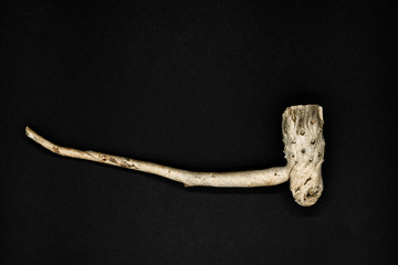Very old and decorative wooden tobacco pipe isolated on black background