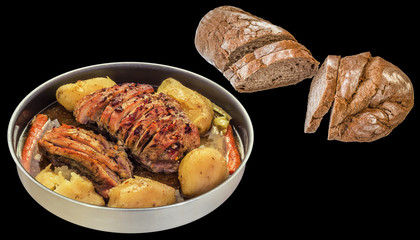 Pork Ham Slices Oven Baked with Whole Potatoes in Round Casserole and Whole Grain Domestic Rustic Brown Bread Cut Loaf Isolated On Black Background
