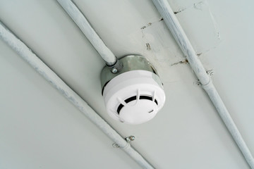Smoke detector sensor on cement ceiling in parking