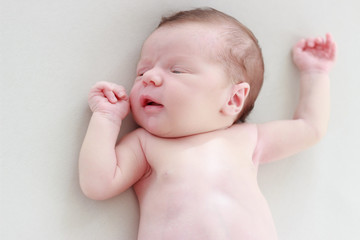 Portrait of a newborn baby laying on a white blanket