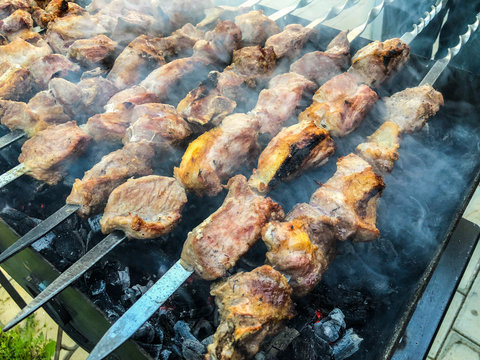 Mcvadi - shashlik preparing on a barbecue grill over charcoal. Roasted stacked meat Shish kebab popular in Goergia. Traditional cuisine in Georgia
