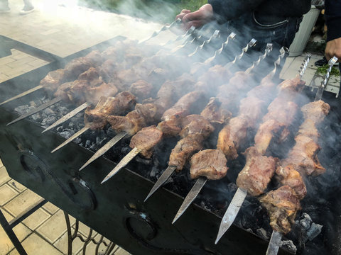 Mcvadi - shashlik preparing on a barbecue grill over charcoal. Roasted stacked meat Shish kebab popular in Goergia. Traditional cuisine in Georgia