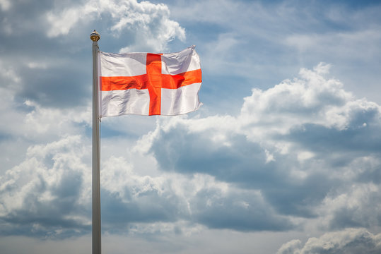 England Flag  in the sky/ National England Flag of Saint George in the wind on a flagpole against a background of clouds in the sky