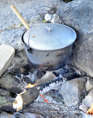 Cooking in a cauldron on an open fire. Preparing food at the stake in a wild camping. to cook...