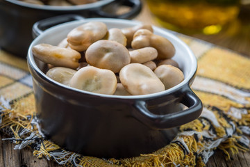 Broad beans served in black bowls.