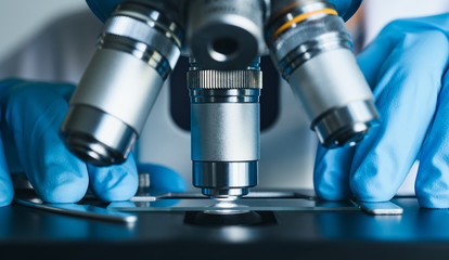 Scientist hands with microscope close-up shot in the laboratory