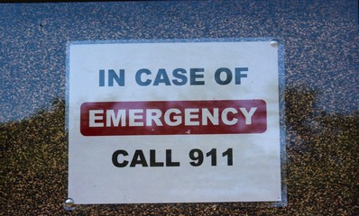 A call emergency number sign on a close view.
