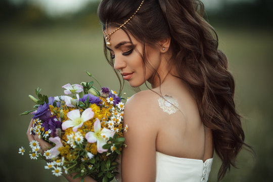 Pretty young bride with bouquet of wildflowers