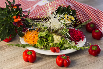 organic vegetables red and yellow peppers, salads and red and white cover on the wooden background.