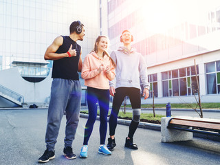 Fototapeta premium Three young athletes talk after training. Training in the city. Sports training in urban conditions. Lifestyle.