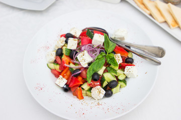Greek salad of fresh vegetables served in a restaurant on a plate