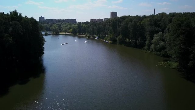 Aerial shot of a cableway in a lake with a wakeboarder grinding and rotating on a funbox