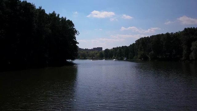 Aerial shot of a cableway in a lake with a wakeboarder grinding and rotating on a funbox